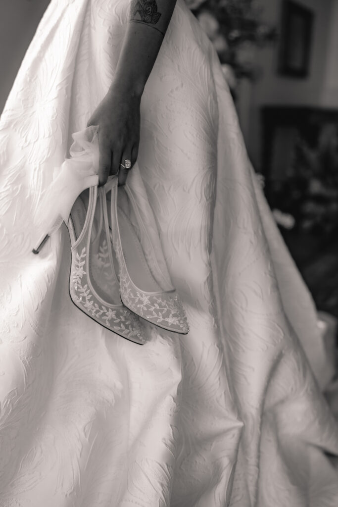 Bride walks with shoes in hand