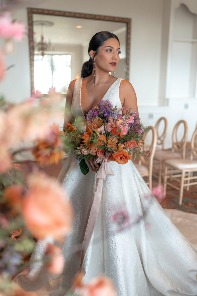 California Bride surrounded by flowers in ceremony room