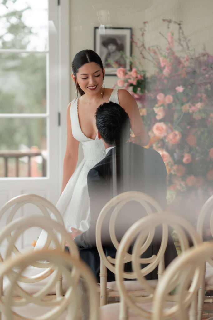 Candid wedding couple through the window with ceremony chairs