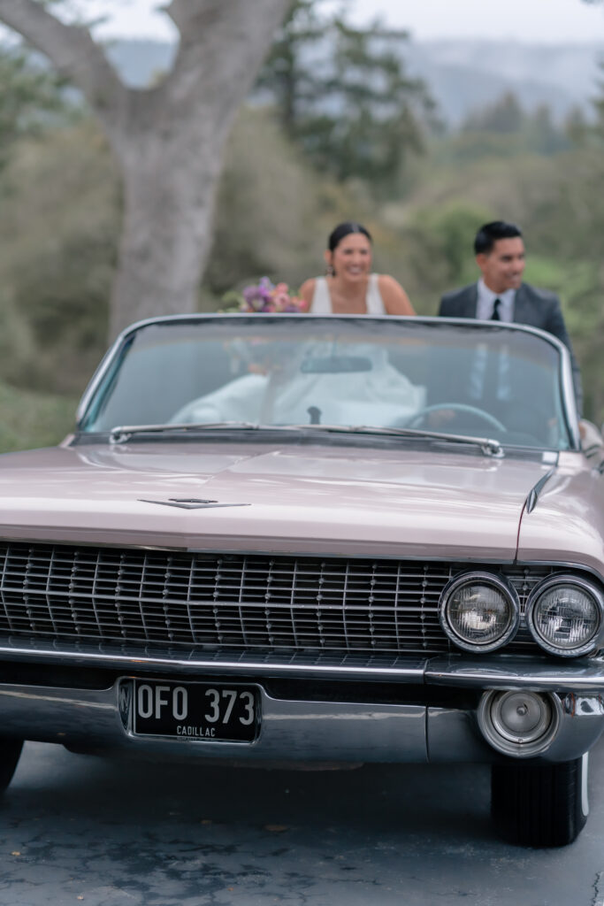 Wedding couple laughing in getaway car